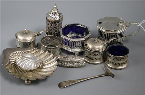 A silver butter shell, silver napkin rings and other items including silver condiments.
